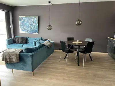 a living room with a blue couch and a table at Ski-in & out Totten Lodge apartment two bedrooms in Hemsedal