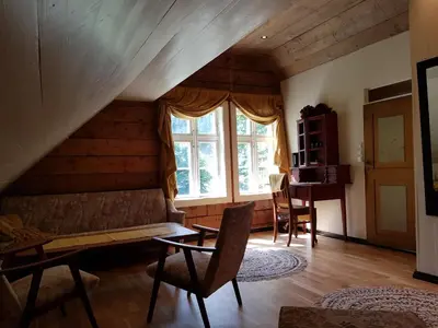 a living room with a couch and a window at Rødseter Gjestegård in Fjarland