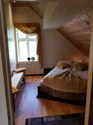 a bedroom with a large bed and a window at Rødseter Gjestegård in Fjarland