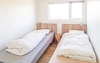 two beds in a room with a window at Beautiful Home In Fitjar in Fitjar