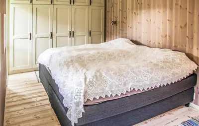 a bedroom with a bed with a white blanket at 4 Bedroom Stunning Home In Skjolden in Skjolden