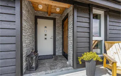a front door of a brick house with a vase of flowers at 4 Bedroom Nice Home In Tustna in Leira