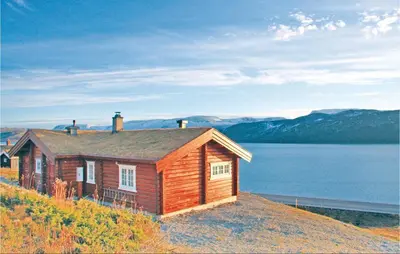 a small house on top of a hill next to a body of water at Holiday Home Hol With A Fireplace 02 in Hovet