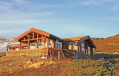 a wooden house on a hill with a mountain at Holiday Home Hol With A Fireplace 02 in Hovet