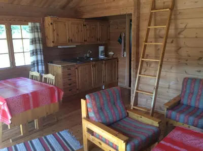 a room with a kitchen and a table and a ladder at Furuly Camping in Nordberg
