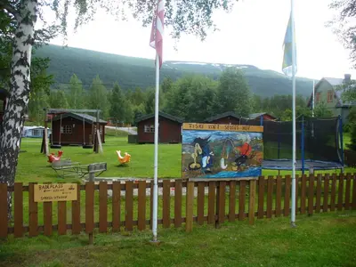 a park with a fence and a playground at Furuly Camping in Nordberg