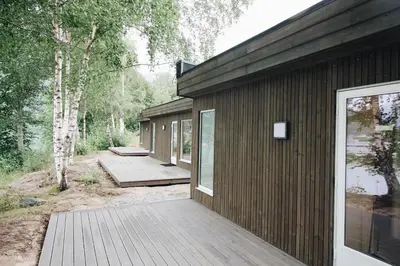 a house with a wooden deck next to a building at Setnes Feriesenter in Veblungsnes