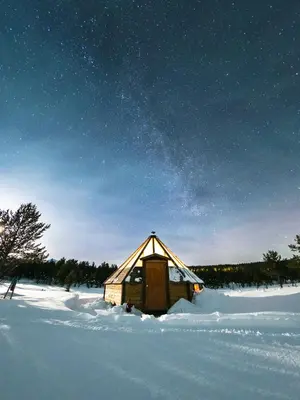a wooden cabin in the snow under a starry sky at Sjodalen Hyttetun og Camping in Stuttgongfossen