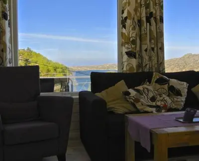 a living room with a couch and a table and a window at Hagland Lille Haugesund 8x Ferienhaus incl Motorboot in Hagland