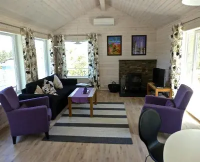 a living room with purple furniture and a fireplace at Hagland Lille Haugesund 8x Ferienhaus incl Motorboot in Hagland