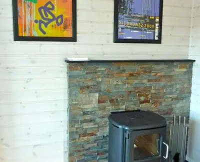 a brick fireplace with a tv in front of it at Hagland Lille Haugesund 8x Ferienhaus incl Motorboot in Hagland