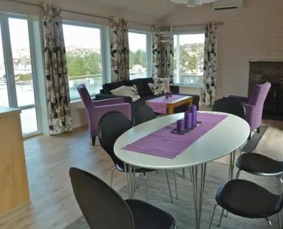 a living room with a table and purple chairs at Hagland Lille Haugesund 8x Ferienhaus incl Motorboot in Hagland
