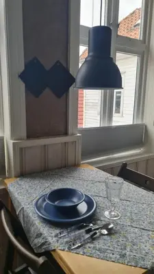 a table with a blue plate and a lamp on it at Amunds Apartment in Bergen