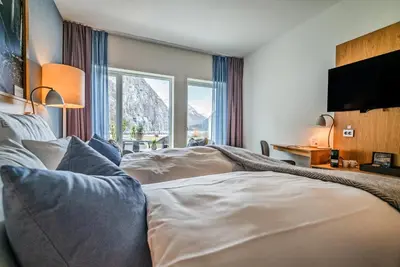 a hotel room with a bed and a large window at Valldal Fjordhotell - by Classic Norway Hotels in Valldal