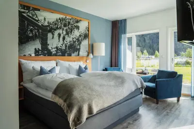 a bedroom with a large bed and a large window at Valldal Fjordhotell - by Classic Norway Hotels in Valldal