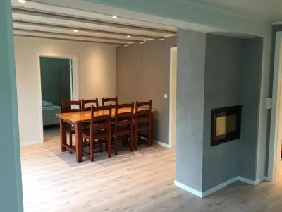 a dining room with a wooden table and chairs at Villa Haudalan Åndalsnes in Åndalsnes