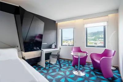 a hotel room with a bed and a table and chairs at Prize by Radisson, Solheimsviken Bergen in Bergen