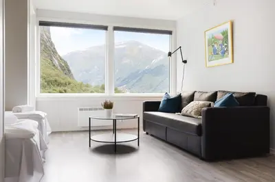 a living room with a couch and a large window at Trolltunga Aparthotel in Tysso