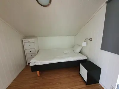 a small room with a bed and a night stand at Lauvøy Feriesenter in Askøy