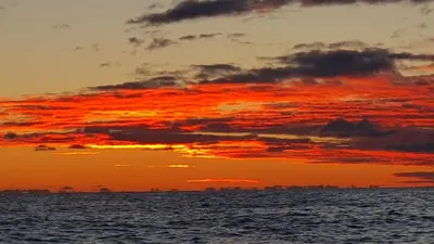 an orange sunset over the ocean with the sky at Lauvøy Feriesenter in Askøy