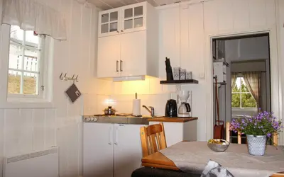 a kitchen with white cabinets and a table with a table sidx sidx at Sandli Overnatting in Alvdal