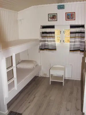 a small room with a bunk bed and a table at Sandli Overnatting in Alvdal