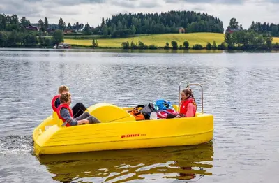 a group of people in a yellow boat on a lake at Steinvik Camping in Moelv