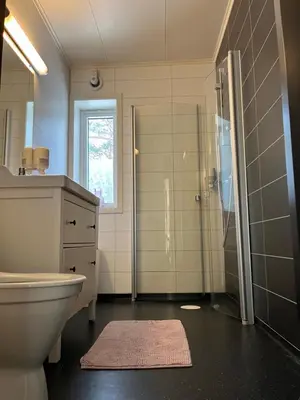 a bathroom with a toilet and a shower and a sink at Bosdalhuset in Lavik