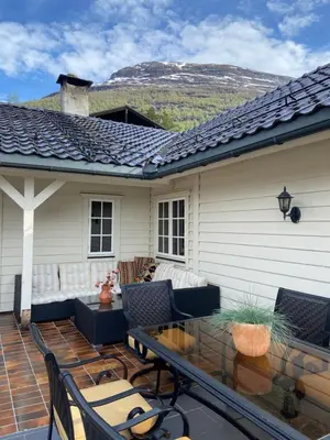 a patio with chairs and a table in front of a house at Aarnes house Stryn in Stryn