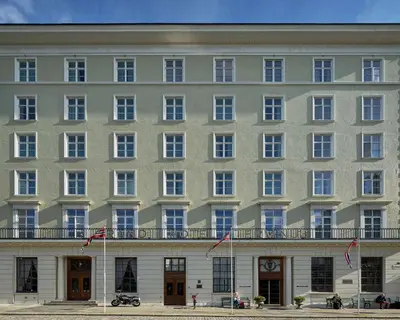 a large white building with flags in front of it at Grand Hotel Terminus in Bergen