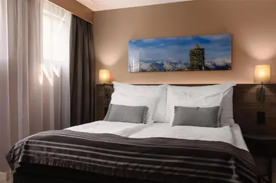 a bedroom with a large bed with two pillows at Scandic Sunnfjord Hotel & Spa in Førde