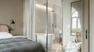a bedroom with a shower and a bed and a tub at Hotel Brosundet in Ålesund