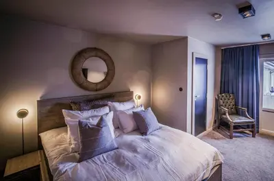 a bedroom with a large bed with pillows and a mirror at Villa Vågå - by Classic Norway Hotels in Vågåmo