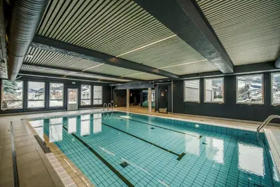 a large swimming pool in a building with windows at Villa Vågå - by Classic Norway Hotels in Vågåmo
