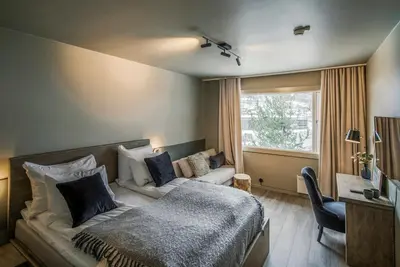 a bedroom with a bed and a couch and a window at Villa Vågå - by Classic Norway Hotels in Vågåmo