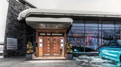 a front door of a building with a car parked outside at Skarsnuten Mountain Resort & SPA in Hemsedal