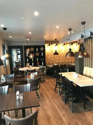 a dining room with wooden tables and chairs at Lampeland Hotel in Lampeland