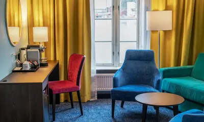 a hotel room with two chairs and a couch at Thon Hotel Kristiansund in Kristiansund