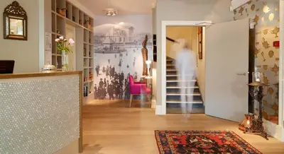 a living room with a hallway with a wall painting of people at Hotel Park Bergen in Bergen