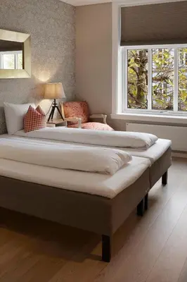 two large beds in a bedroom with two windows at Hotel Park Bergen in Bergen