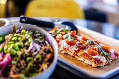 two slices of pizza and a salad on a table at Thon Hotel Hallingdal in Ål