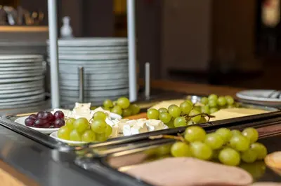 a bunch of grapes and cheese on a table at Dombås Hotel in Dombås