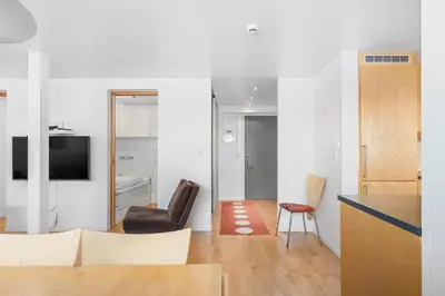 a living room with a chair and a television at Voss Resort self-service apartments in Skulestadmo