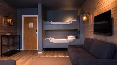 a living room with a couch and two bunk beds at Skogstad Hotel - Unike Hoteller in Hemsedal
