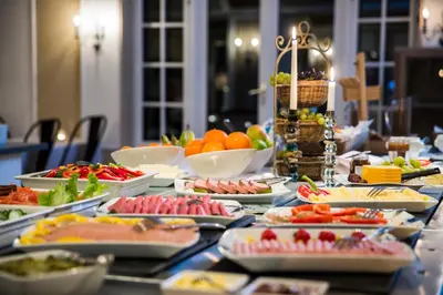 a table topped with plates of food and bowls of fruit at Skogstad Hotel - Unike Hoteller in Hemsedal