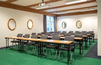 a conference room with tables and chairs and mirrors at Thon Hotel Skeikampen in Svingvoll