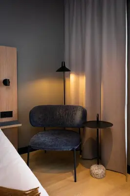 a chair sitting next to a table in a room at Quality Hotel Grand Steinkjer in Steinkjer