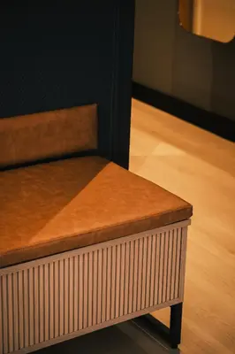 a bench in a room with a wooden floor at Quality Hotel Grand Steinkjer in Steinkjer