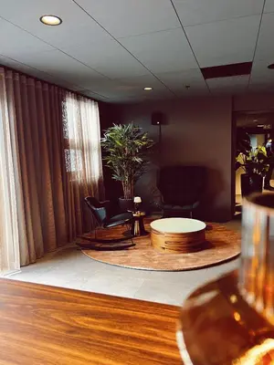 a living room with a table and chairs and a couch at Quality Hotel Panorama in Trondheim