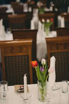 a table with a vase of flowers and candles on it at Grand Hotel Hønefoss in Hønefoss